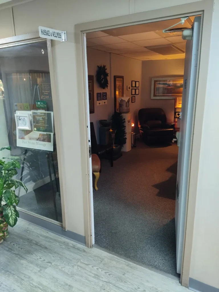Welcoming interior of a massage therapy room with cozy seating and soft lighting.
